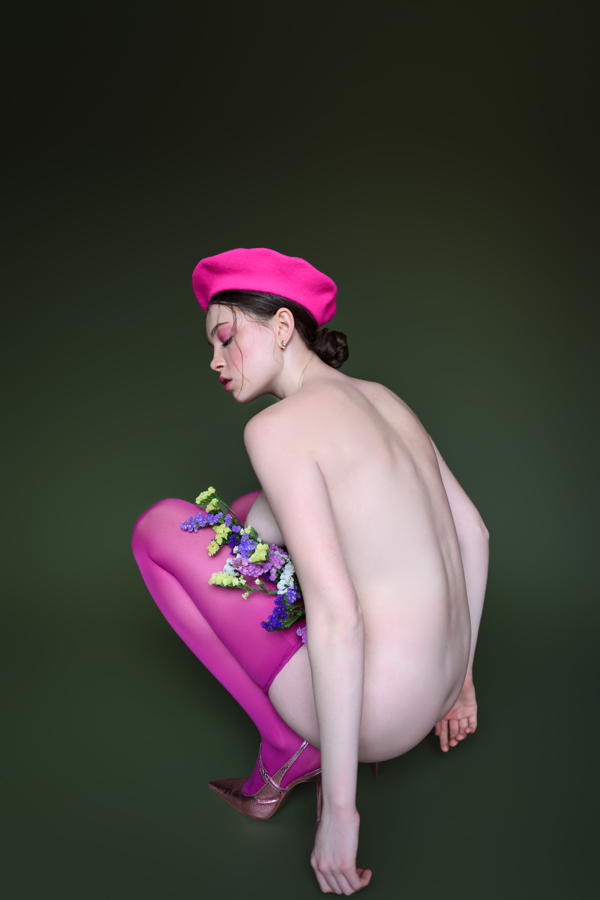 Elegant fine-art nude suggested amid floral shadows